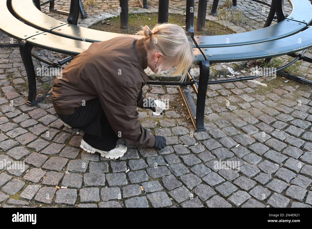 Kastrup/Kopenhagen /Denmmark/08 Febraur 2023/Restaurantarbeiterin, die Zigarettenabfälle in der dänischen Hauptstadt sammelt (Foto: Francis Joseph Dean/Dean Pictures) Stockfoto