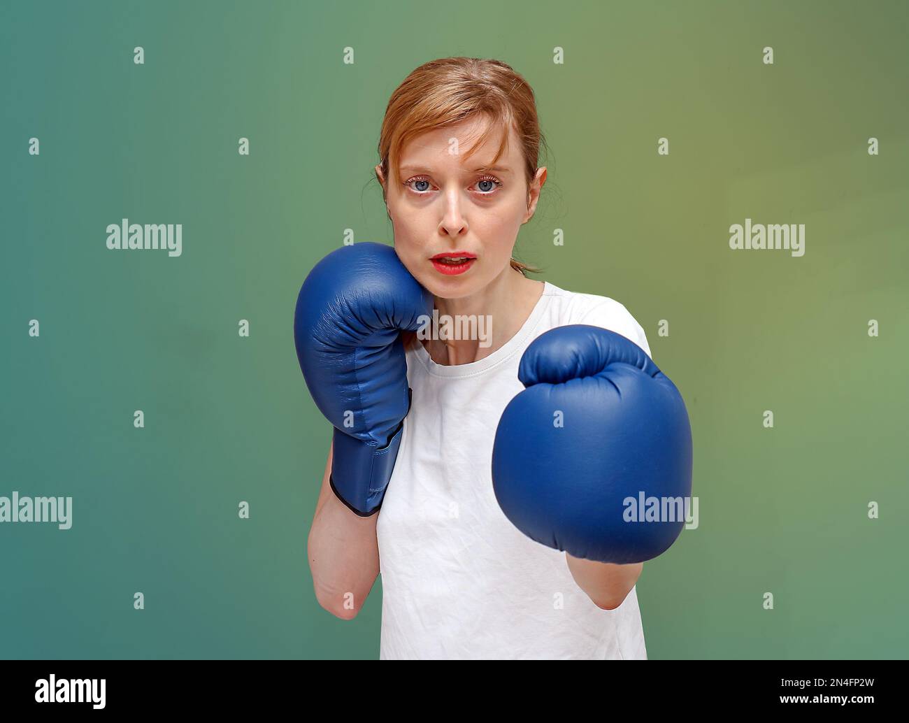 Junge Sportlerin mit Boxhandschuhen, die sich auf das Sportspiel vorbereiten Stockfoto