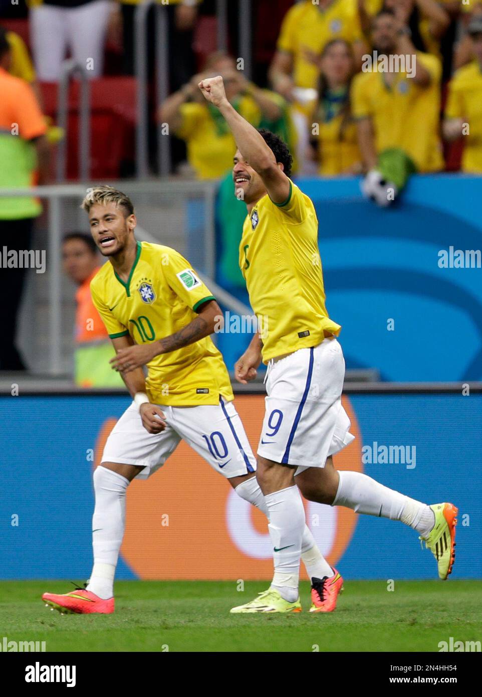 Brazil's Fred celebrates with teammate Neymar, left, after scoring his side's third goal during the group A World Cup soccer match between Cameroon and Brazil at the Estadio Nacional in Brasilia, Brazil, Monday, June 23, 2014. (AP Photo/Andre Penner) Stockfoto