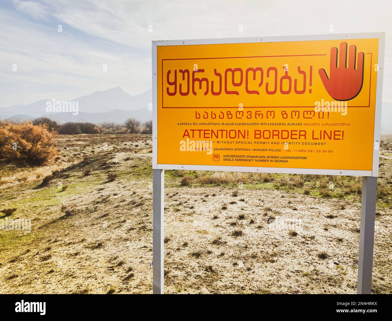 Warnschild für Grenzzone zwischen Aserbaidschan und Georgien. Fluss, der die Berggrenze überquert. Stockfoto