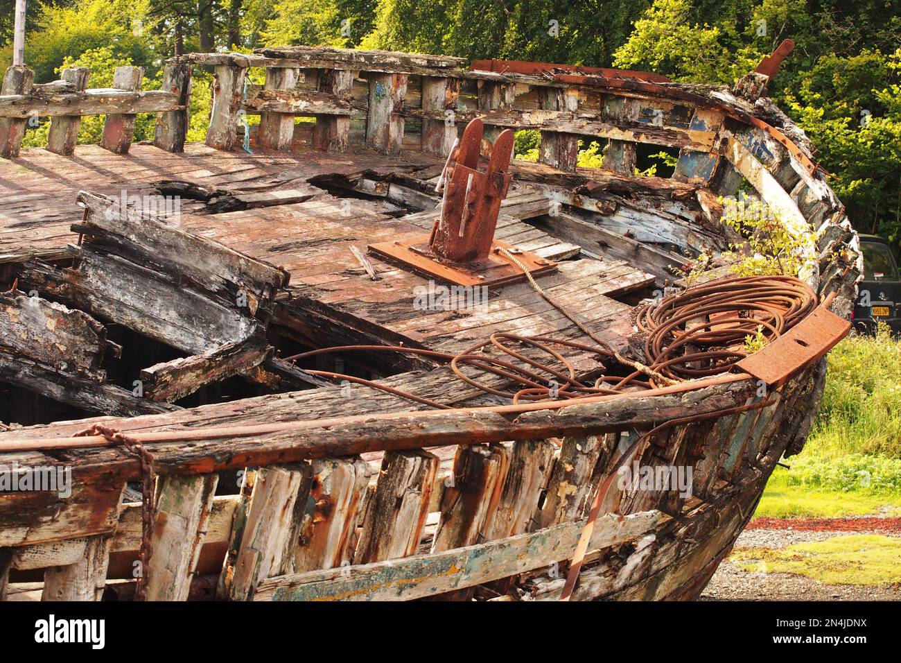 Der Blick hinunter auf den Bug eines alten Holzschiffes, das verfällt, zeigt die Knochen seiner Konstruktion sowie Ketten, Seile und Metallteile Stockfoto