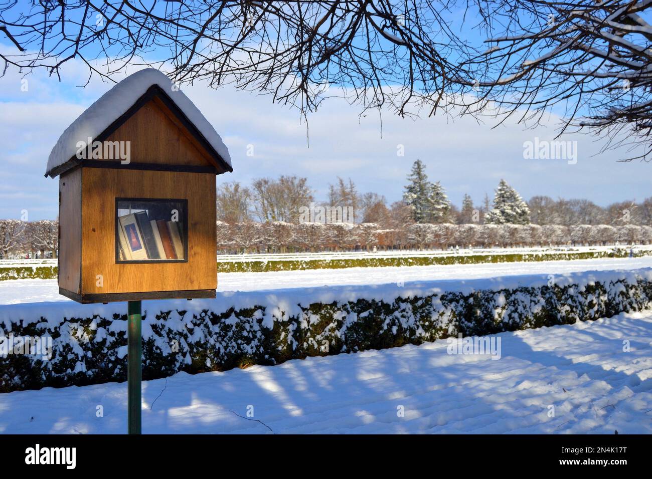 Hölzerne Nistkästen wurden in eine kostenlose öffentliche Bibliothek umgewandelt. Bücherbox in der verschneiten Landschaft des Schlossparks. Winter im Schloss Holesov. Stockfoto