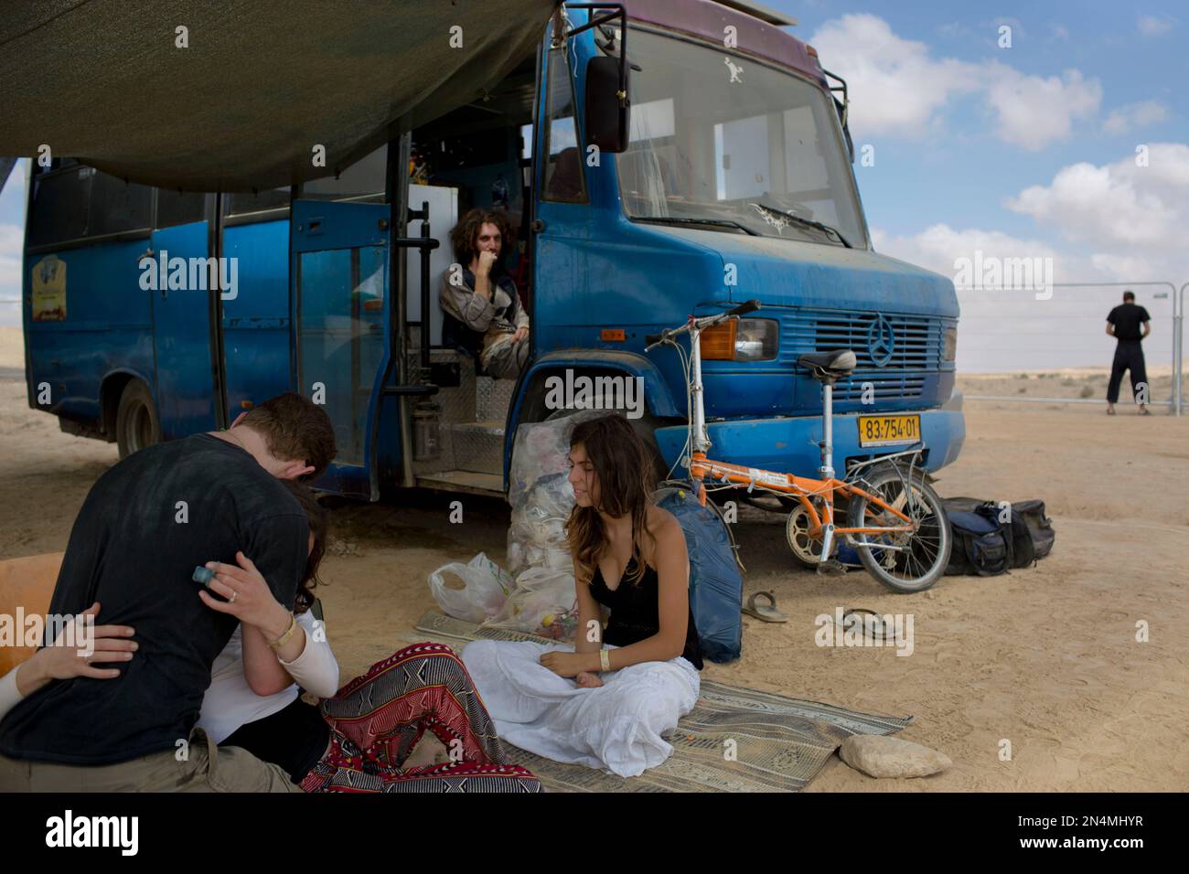 In this photo taken Saturday, June 7, 2014, Israelis sits under the shade during Israel’s first Midburn festival, modeled after the popular Burning Man festival held annually in the Black Rock Desert of Nevada, in the desert near the Israeli kibbutz of Sde Boker. For five days, participants, mostly Israelis ,created a temporary city dedicated to creativity, communal living, and what the festival calls “radical self-expression." (AP Photo/Oded Balilty) Stockfoto