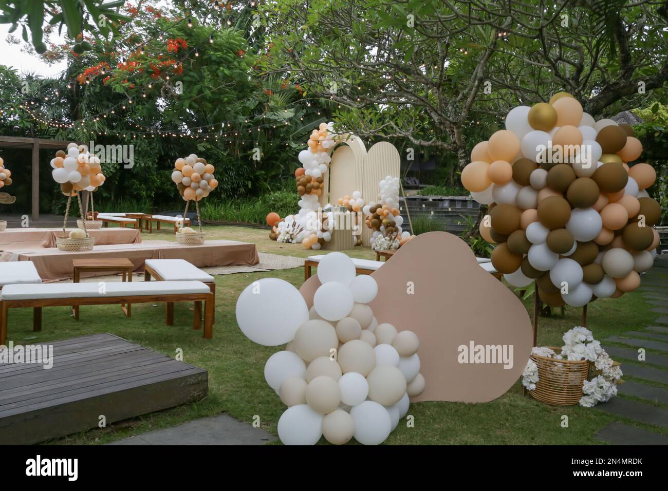 Kreative geschlechtsneutrale Babyparty oder Geburtstagsdekoration im Garten. Veranstaltung im Freien im böhmischen Stil mit Ballons. Weißes cremefarbenes Pfirsichkaramell Stockfoto