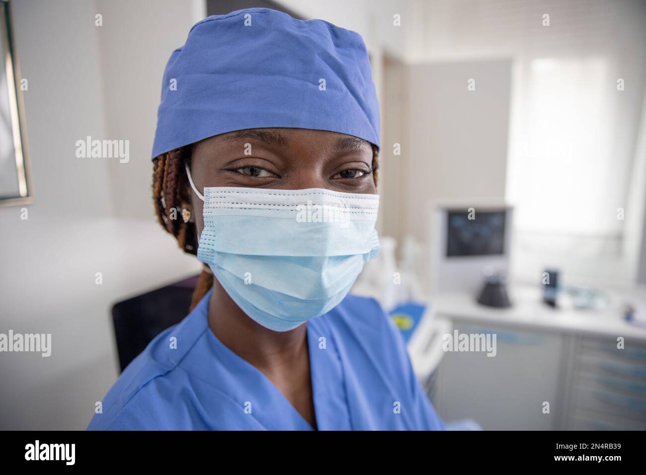 Porträt einer afrikanischen Ärztin in ihrer Praxis, die eine Operationsmaske trägt. Stockfoto