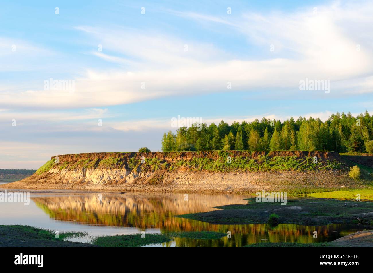 Der steile Hang des Ufers mit unterschiedlichem Ton und Sand von den nördlichen Flüssen von Yakutia, dem hellen Tag von Vilyuy in der Tundra. Stockfoto