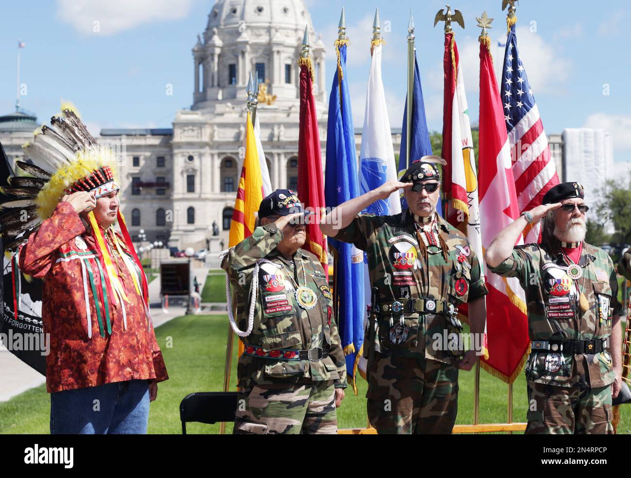 Native American honor guard veterans salute during a ceremony Thursday, May 22, 2014, at the Minnesota State Capitol Court of Honor in St. Paul. Minn. where a plaque honoring those veterans who have served in peacetime and war was unveiled. (AP Photo/Jim Mone) Stockfoto