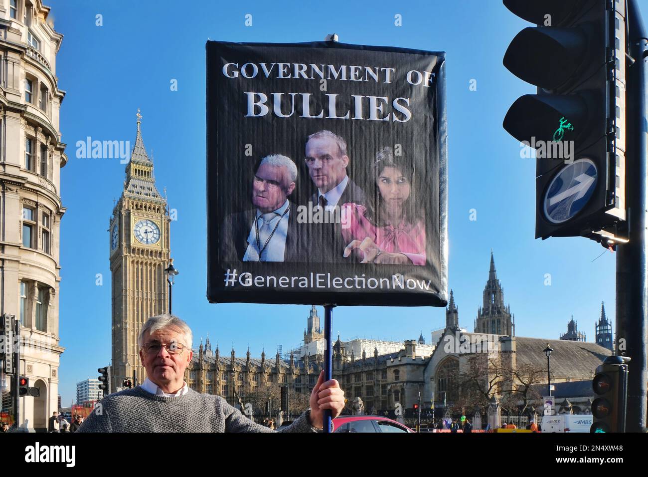 London, Großbritannien. Ein Protestteilnehmer steht gegenüber dem Parlament mit einem Plakat, auf dem eine allgemeine Wahl für eine Regierung gefordert wird, die von mehreren Skandalen erschüttert wurde. Stockfoto