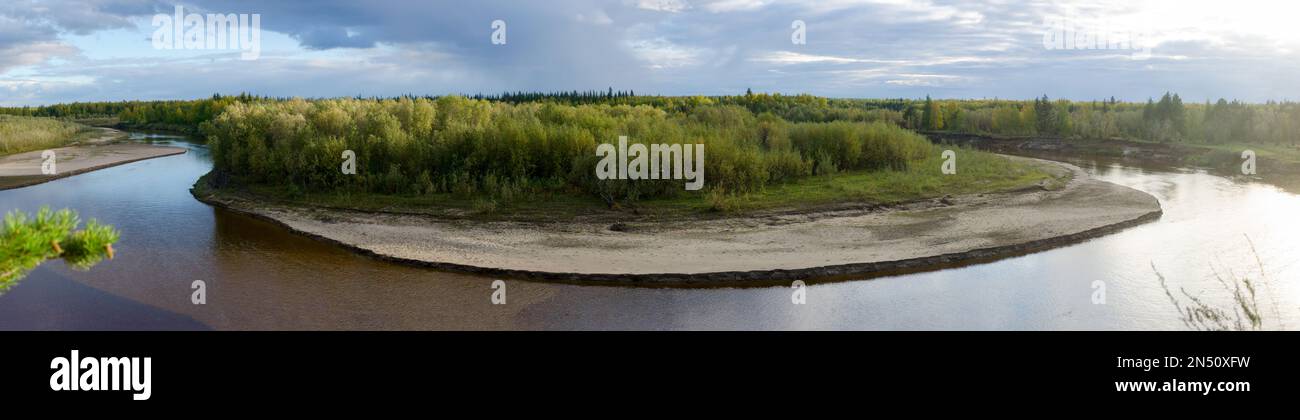 Panorama der Wende der nördlichen Flüsse Kempendyay mit der Halbinsel bis zum Ufer des Sandstrands im Fichtenwald, der Tundra von Yakutia und den geschwollenen Wolken. Stockfoto