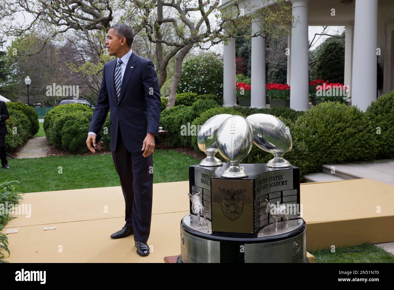 President Barack Obama stands by the Commander-in-Chief's Trophy after a ceremony presenting it to the United States Naval Academy football team in the Rose Garden of the White House in Washington, Friday April 18, 2014. Navy finished the 2013 season with a 9-4 record, won the Commander-in-Chief's Trophy for the ninth time in the last 11 years. (AP Photo/Jacquelyn Martin) Stockfoto