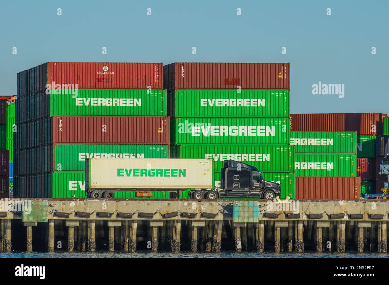 Hafen von Los Angeles, Kalifornien, USA - 7. Februar 2023: Gestapelte Versandcontainer und Sattelschlepper bei Everport Terminal Services. Stockfoto