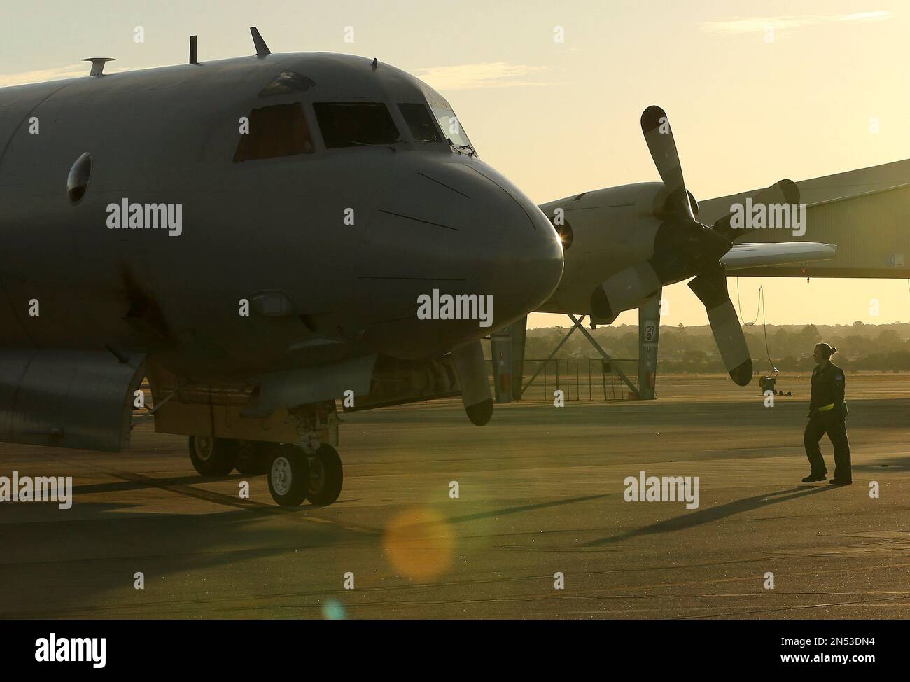 A flight crewman from a Royal Australian Air Force P-3 Orion walks towards the aircraft at RAAF Base Pearce as it arrives back from the on-going search operations for missing Malaysia Airlines Flight MH370 in Perth, Australia, Tuesday, April 8, 2014. Search crews have failed to relocate faint sounds heard deep in the Indian Ocean, possibly from the missing Malaysian jetliner's black boxes whose batteries are at the end of their life. (AP Photo/Rob Griffith) Stockfoto