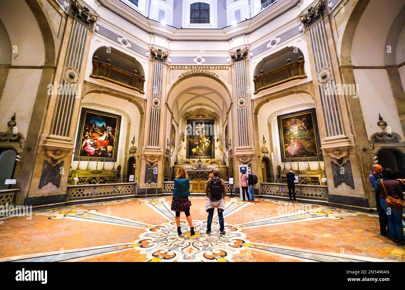 Die Leute schauen sich Caravaggios Gemälde an, die Sieben Gnadenwerke, in der Kapelle. Im Pio Monte della Misericordia in Neapel, Neapel, Italien, Italien Stockfoto