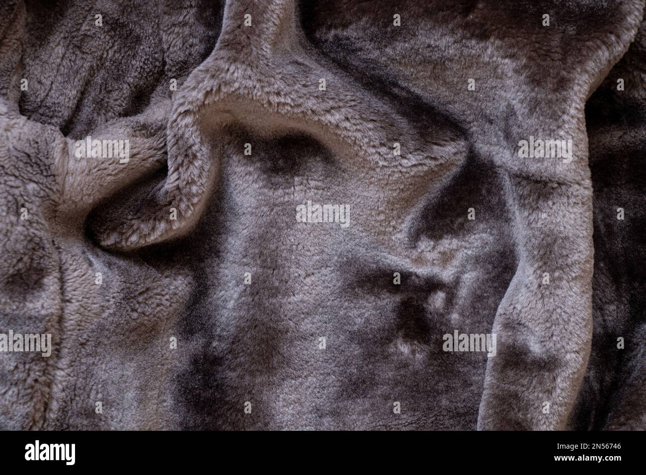 Hintergrund eines schwarzen Männermantels aus Schaffellack aus Kunstfell, Fellhintergrund Nahaufnahme Stockfoto