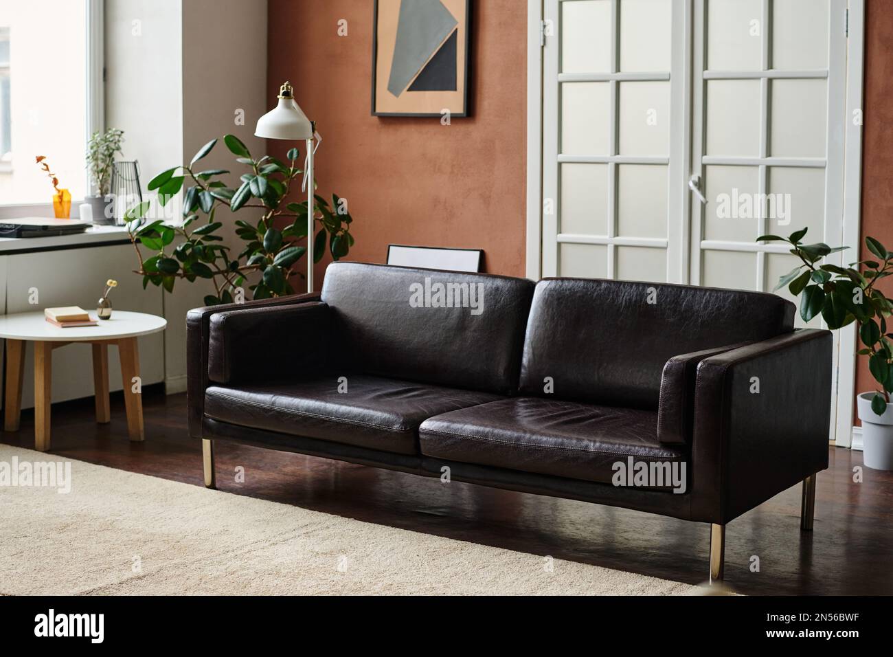 Helles großes Apartment mit komfortablem Sofa in der Mitte und anderen modernen Möbeln Stockfoto