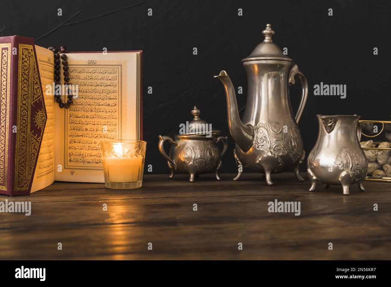 kerze aus koran in der Nähe des Teesets. Auflösung und hochwertige Fotos Stockfoto