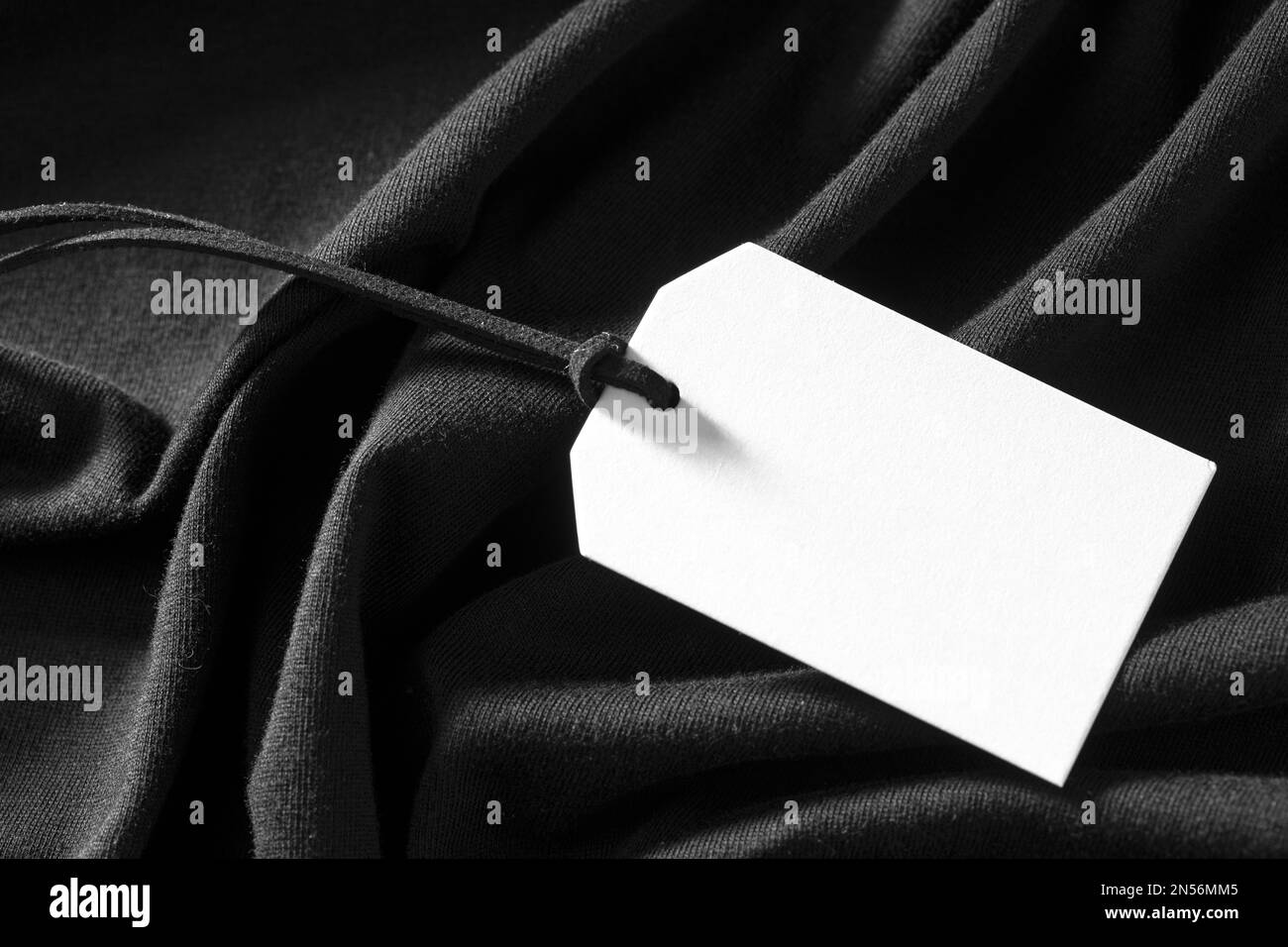 Weißes leeres Etikett auf schwarzem Tuch. Auflösung und hochwertige Fotos Stockfoto