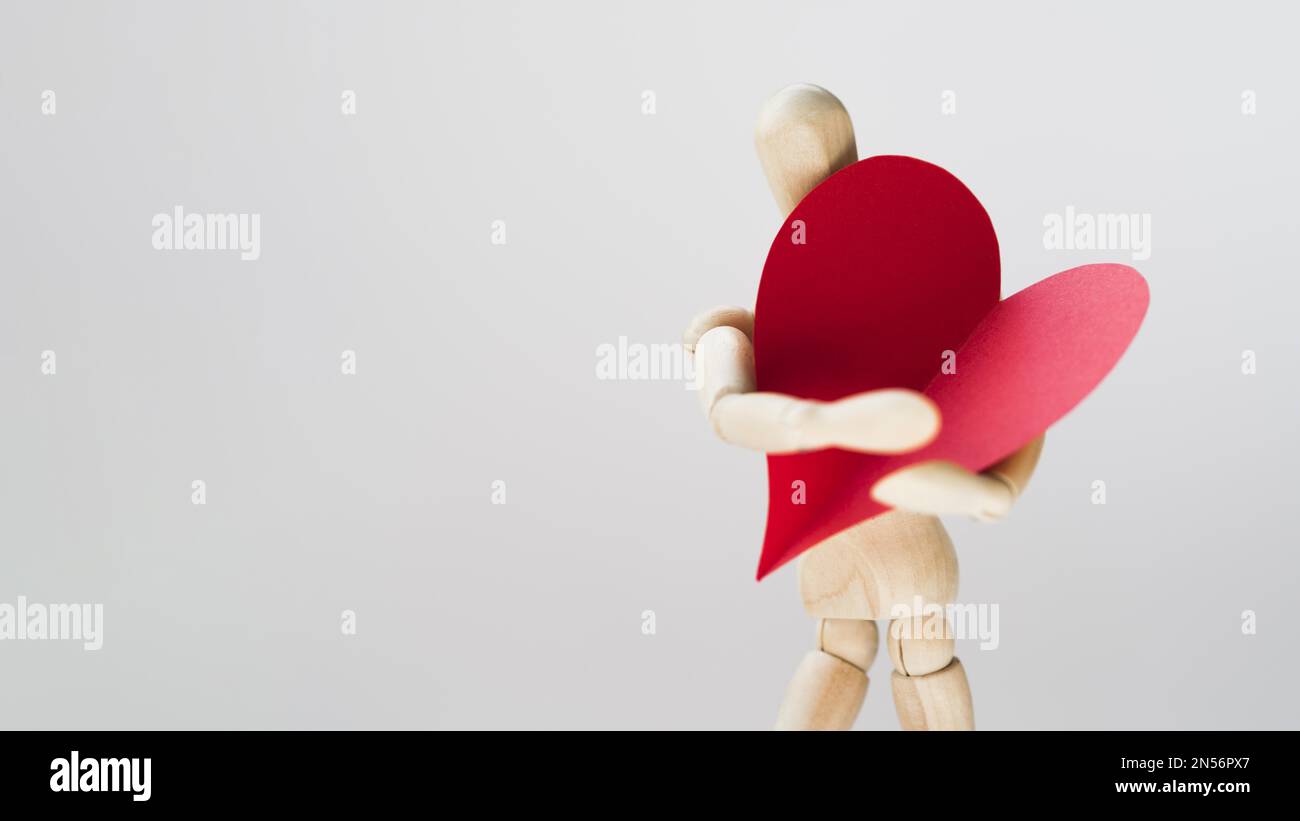 Spielzeugmanequin hält Herz mit Kopierraum. Auflösung und hochwertige Fotos Stockfoto