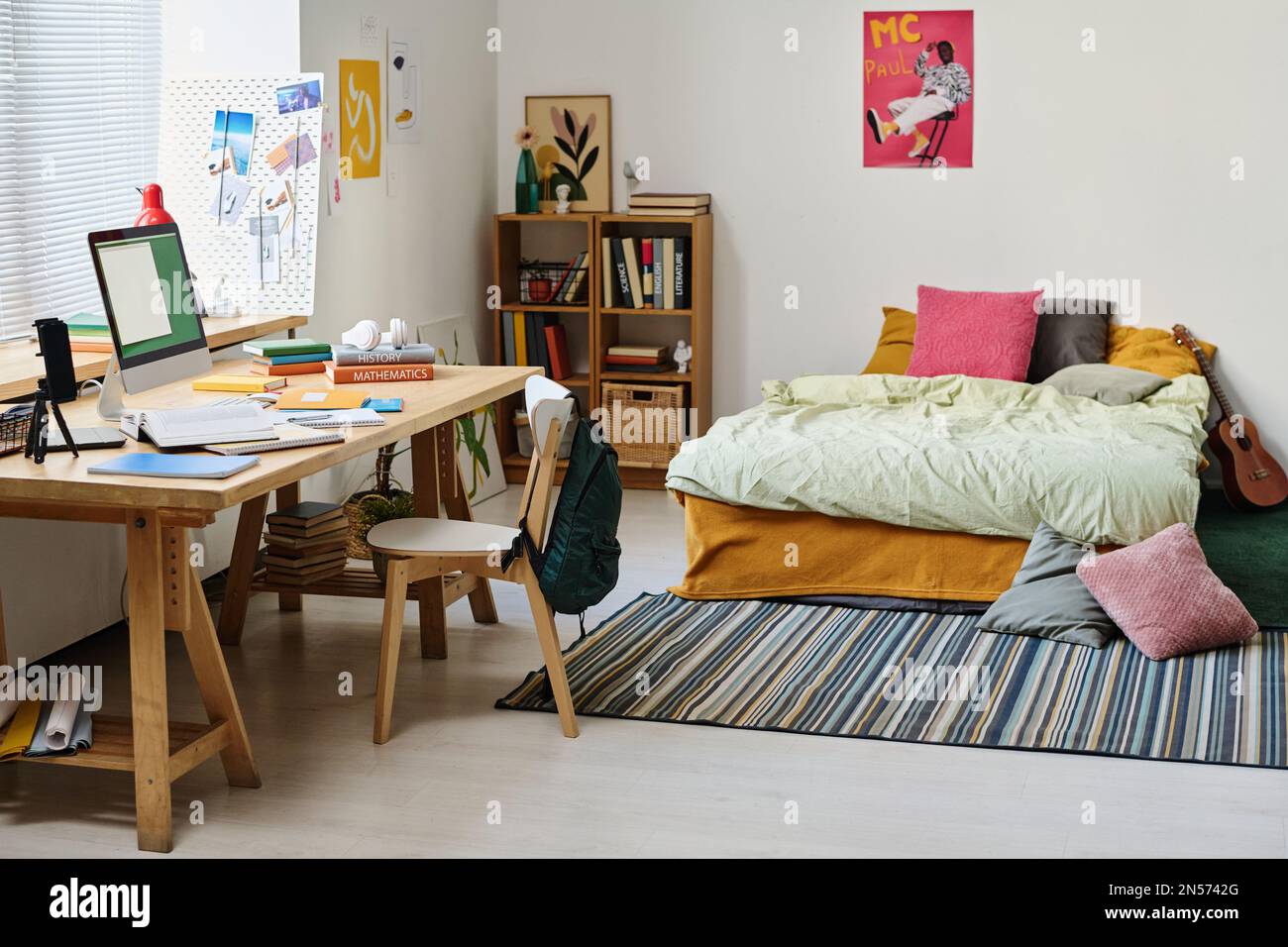 Horizontales Bild eines modernen Zimmers mit Teenager und Schreibtisch mit Computermonitor Stockfoto
