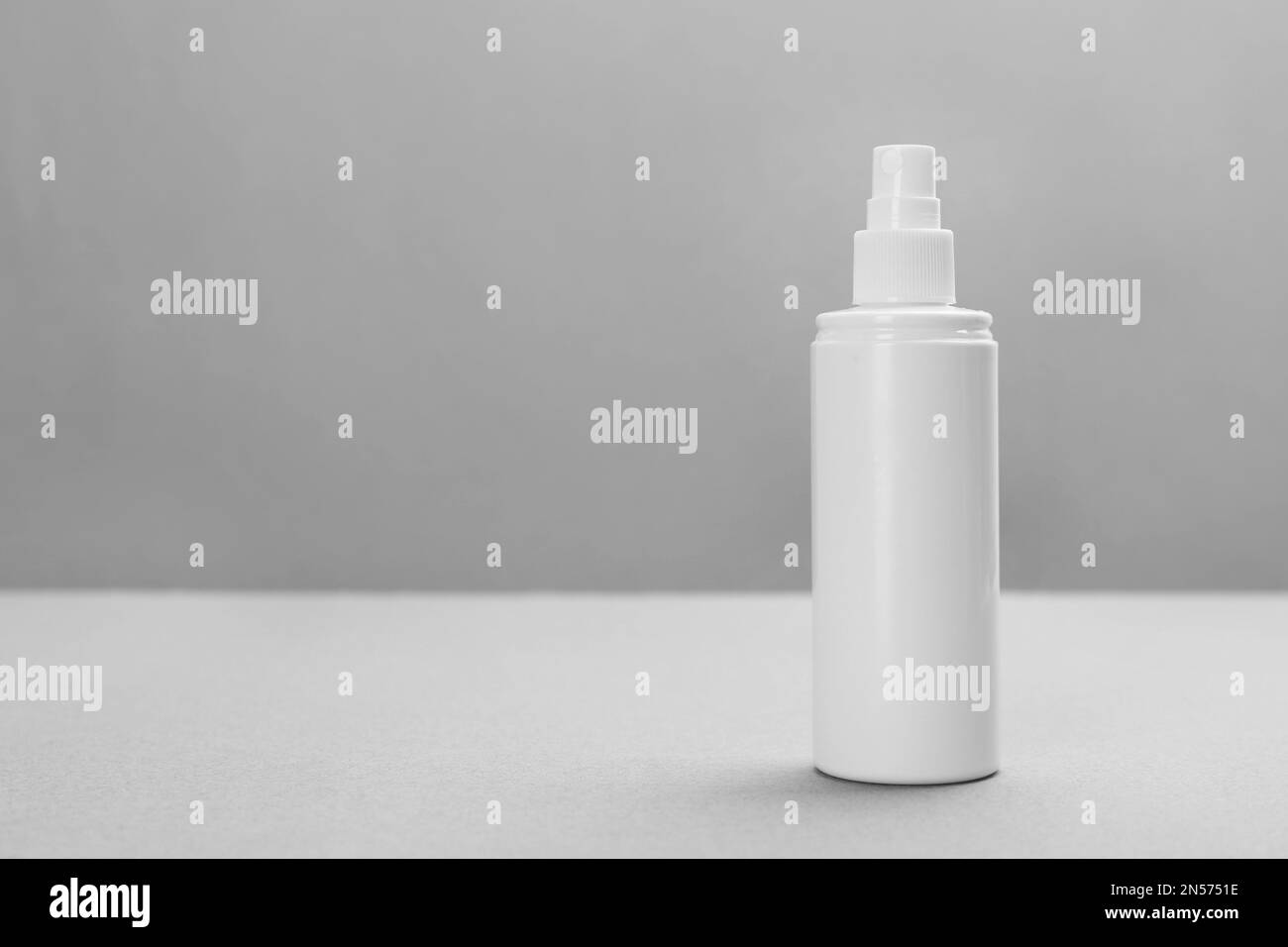 Flasche mit Insektenschutzspray auf grauem Hintergrund, Platz für Text Stockfoto
