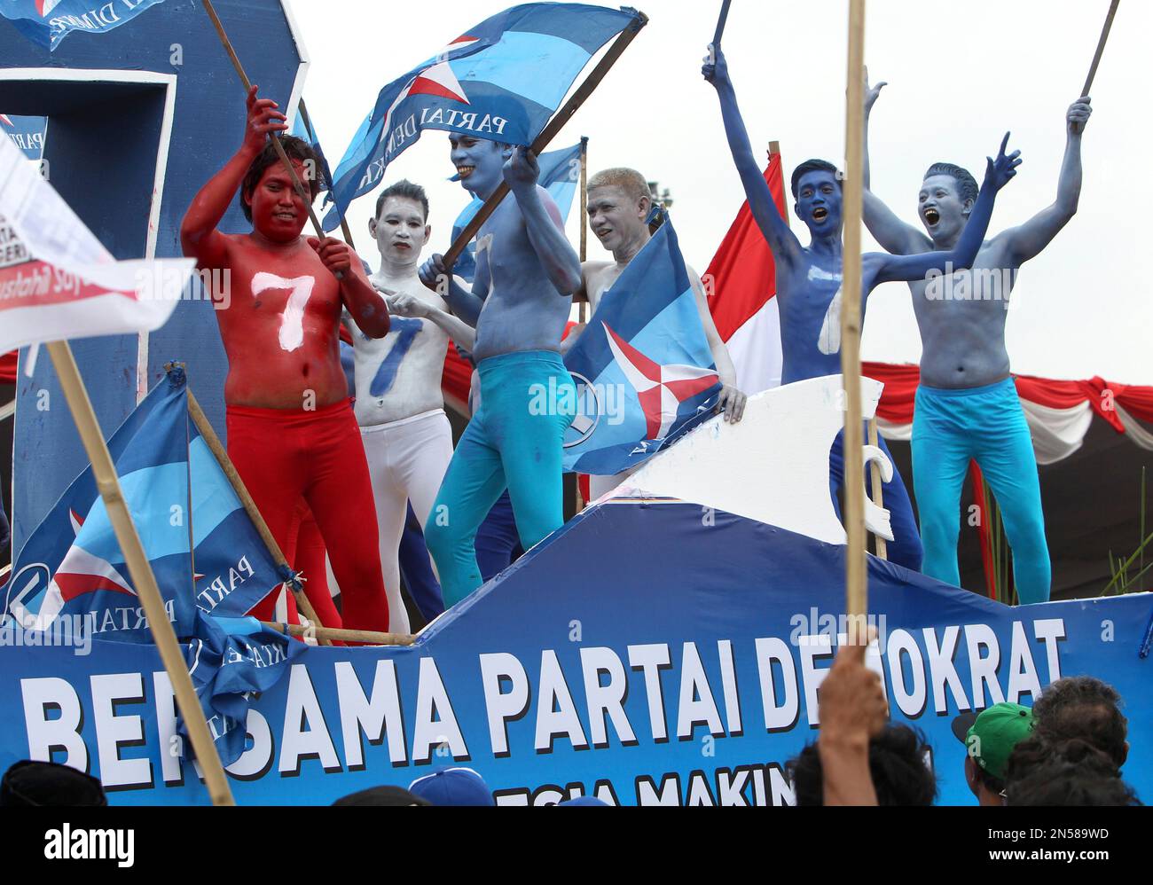 Performers on a ruling Democratic Party's float take part in a parade calling for a peaceful election, one day before the Indonesian parliamentary election period kicks off, in Jakarta, Saturday, March 15, 2014. Indonesia, home to more than 240 million people, the world's third-largest democracy after India and the United States is scheduled to hold its parliamentary election on April 9 and presidential poll in July. (AP Photo/Tatan Syuflana) Stockfoto