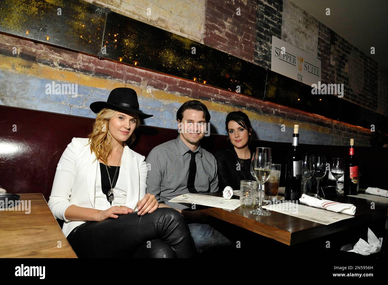 Maggie Grace, from left, Jason Ritter, and Melanie Lynskey, pose at the "We'll Never Have Paris" SxSw cast dinner at Supper Suite By STK hosted by Blue Moon Brewing Co., on Monday, March 10, 2014, in Austin, Texas. (Photo by Darren Abate/Invision for STK/AP Images) Stockfoto