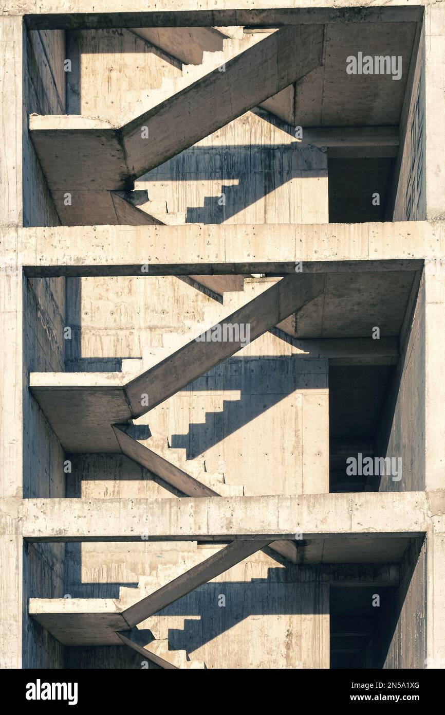 Betontreppen auf der Baustelle. Hausbau. Abstrakter Hintergrund für minimales geometrisches Architekturmuster. Vertikale Ausrichtung Stockfoto