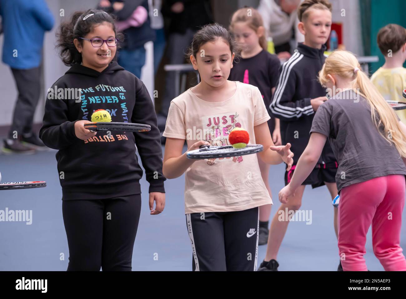 Kinder, die Tennis spielen und Tennisunterricht nehmen Stockfoto