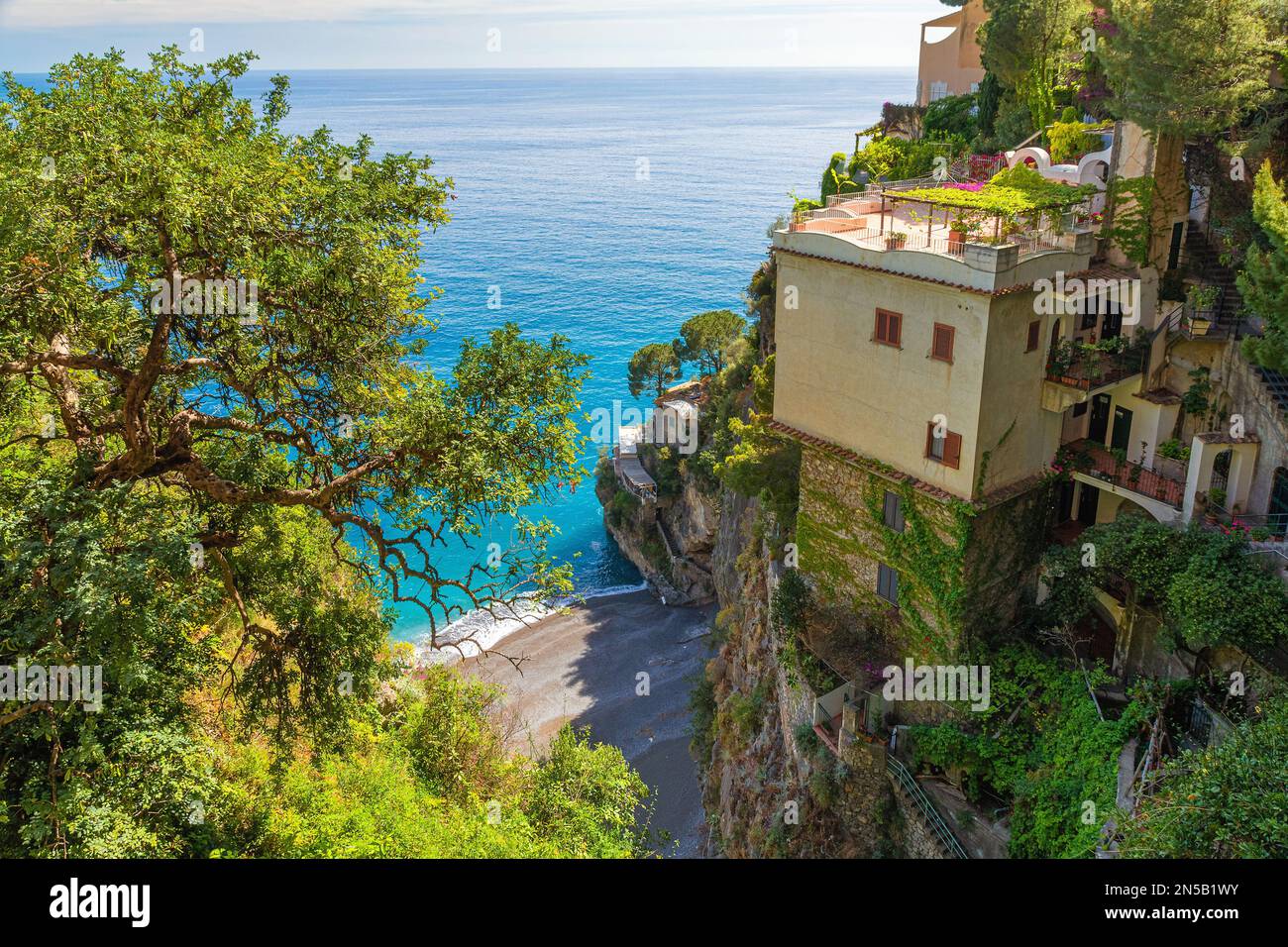 Wunderschöne Aussicht auf die italienische Villa an der Amalfiküste auf der Klippe über dem Mittelmeer mit kleinem Strand. Sommerresort. Reiseziel Stockfoto