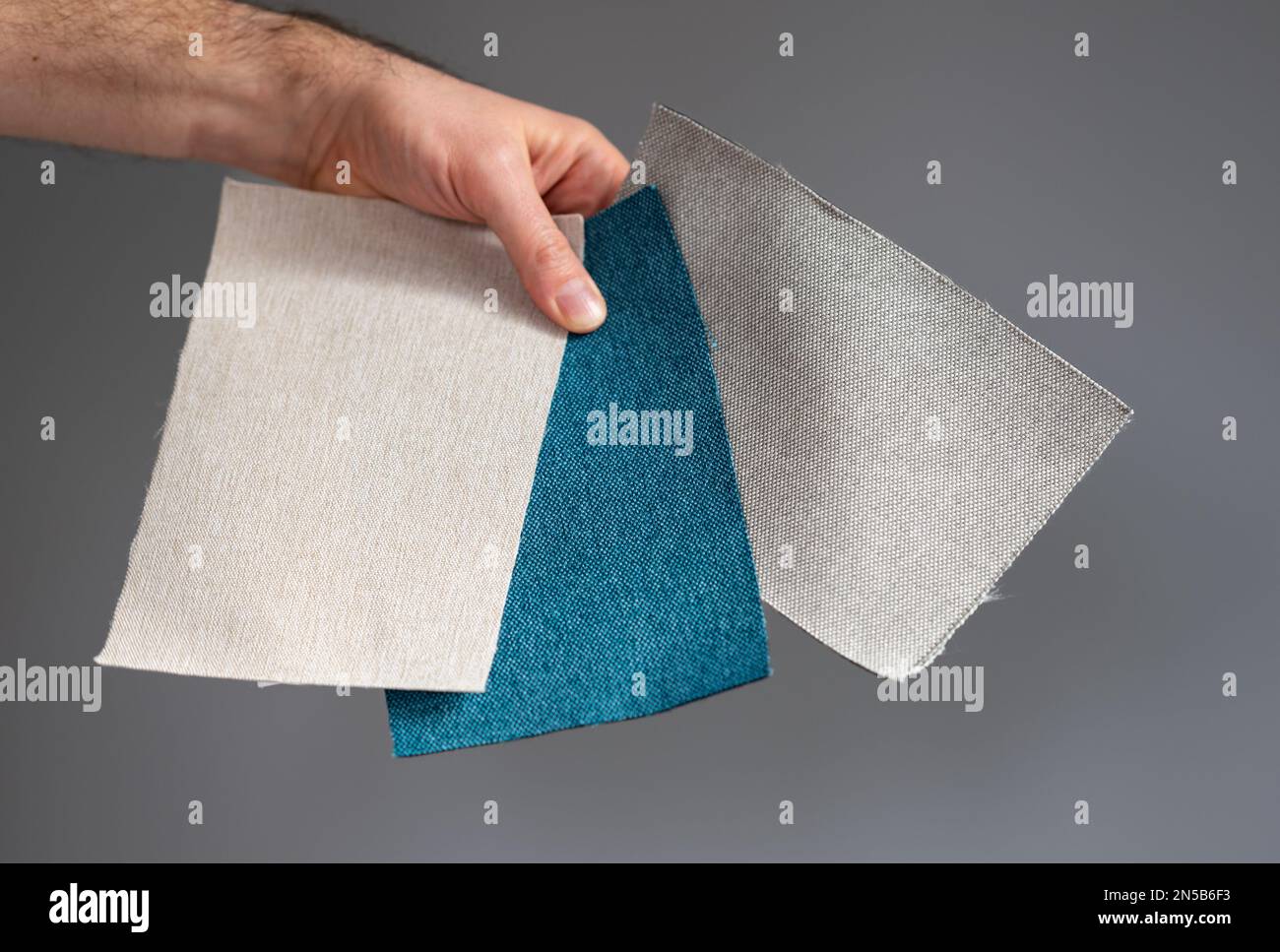 Auswahl des Materials, das zu einer grauen Wand passt. Stockfoto
