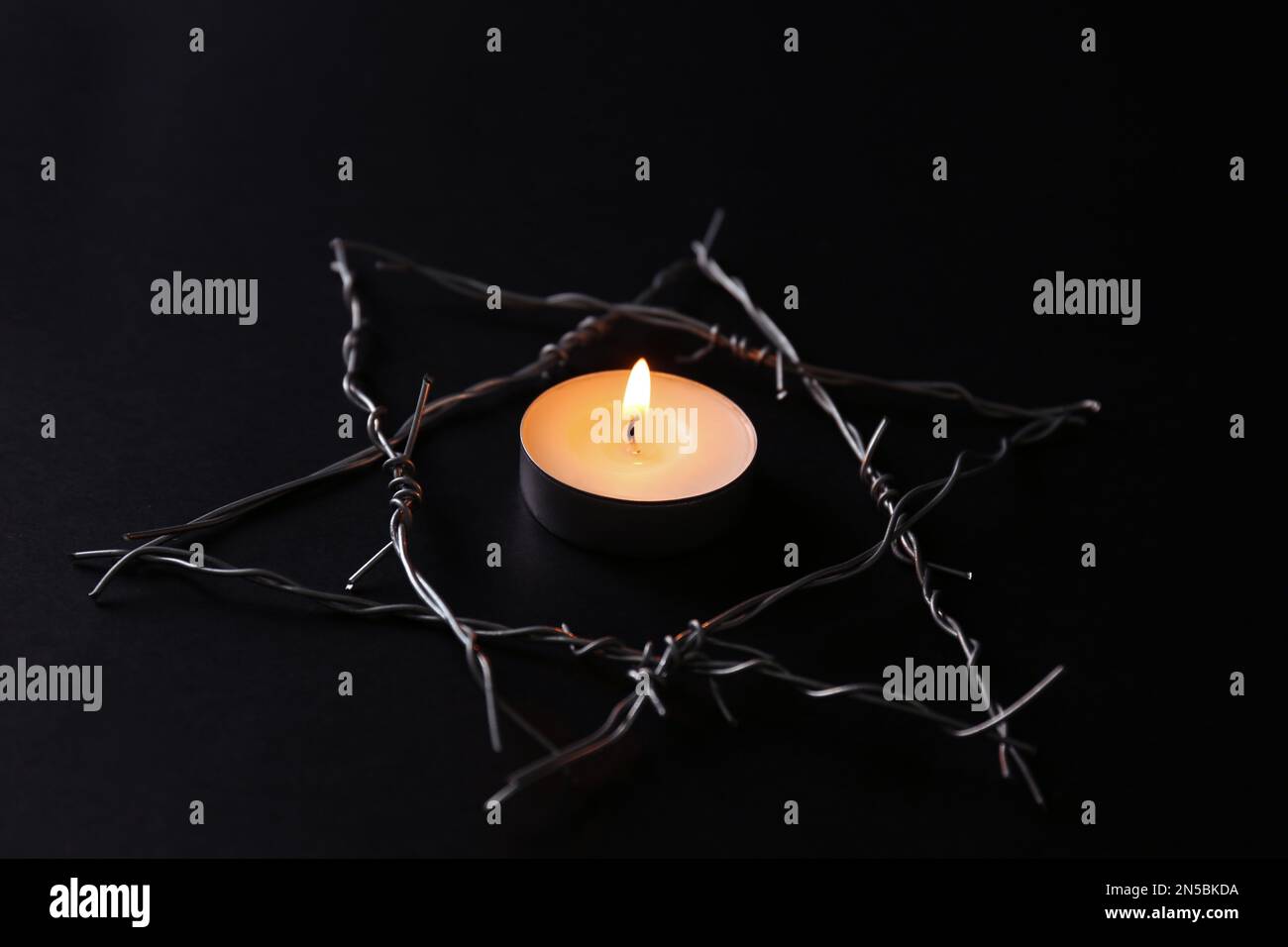 Brennende Kerze und Davidstern mit Stacheldraht auf schwarzem Hintergrund.  Holocaust-Gedächtnisfeiertag Stockfotografie - Alamy