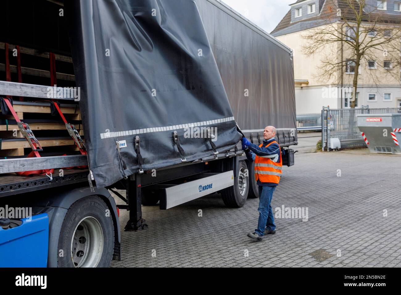 Güterverkehr, professionelle Fahrer beim Öffnen der LKW-Plane in der Ladezone Stockfoto