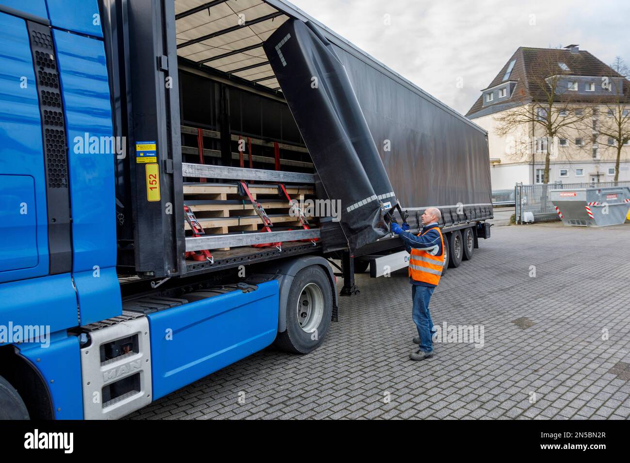 Güterverkehr, professionelle Fahrer beim Öffnen der LKW-Plane in der Ladezone Stockfoto
