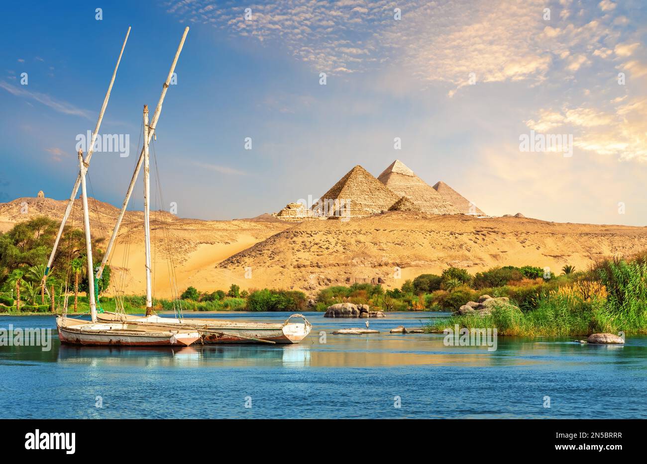 Landschaft von Assuan mit Segelbooten im Nil auf dem Weg zu den Pyramiden in Ägypten Stockfoto
