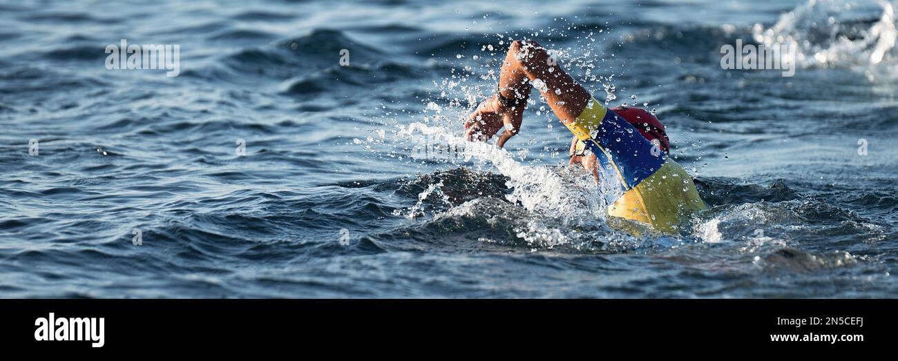 Professioneller Triathlet schwimmt im offenen Meer, männlicher Triathlon schwimmt im professionellen Triathlon Anzug Training Stockfoto
