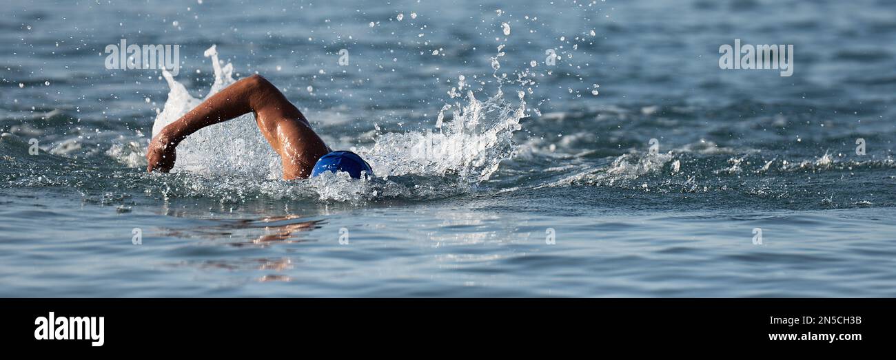 Professioneller Triathlet schwimmt im offenen Meer, männlicher Triathlon schwimmt im professionellen Triathlon Anzug Training Stockfoto
