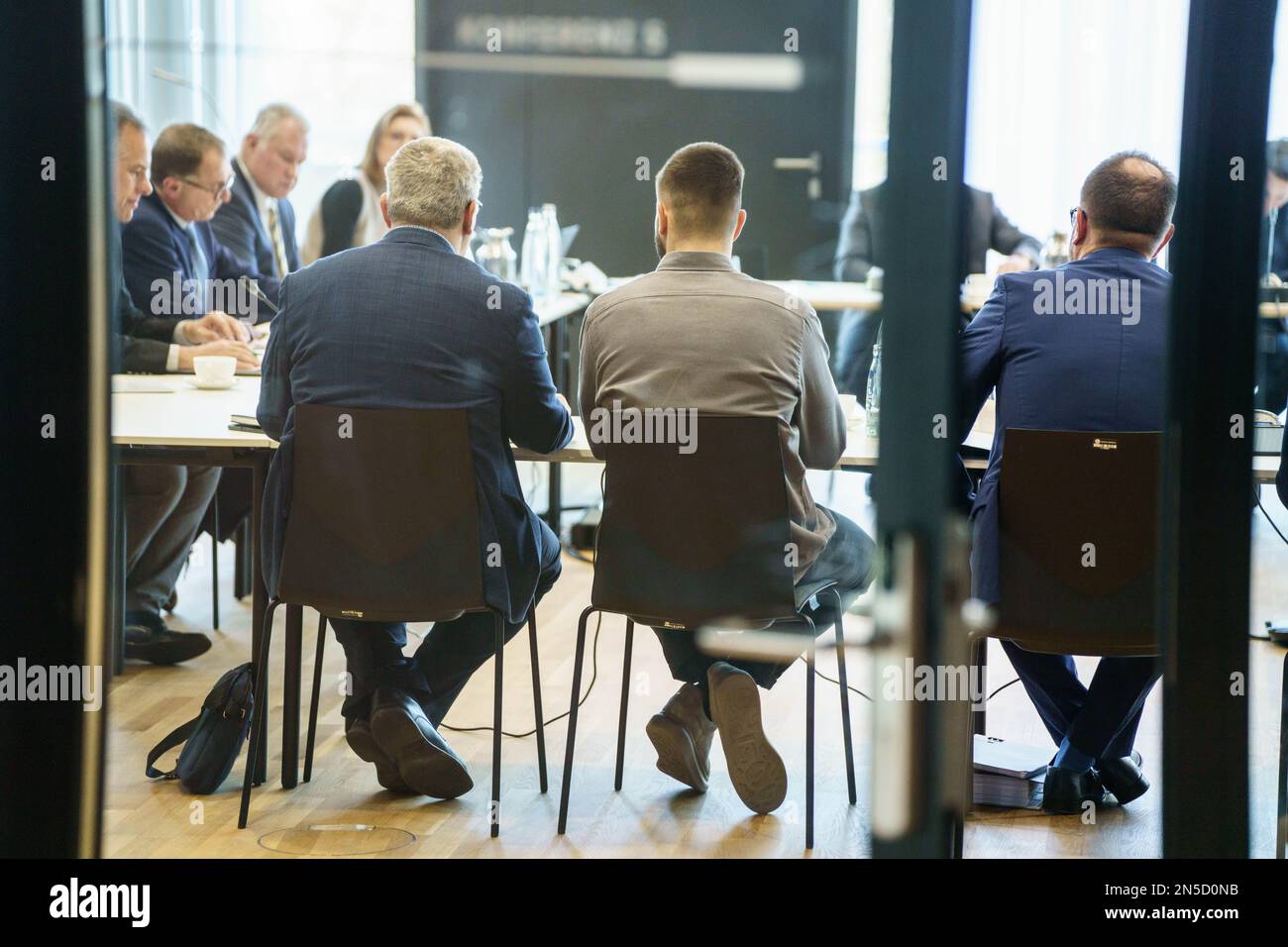 09. Februar 2023, Hessen, Frankfurt/Main: Mario Vuskovic (Front M), Spieler des zweiten Fußballvereins Hamburger Sportverein (HSV), befindet sich neben dem Übersetzer Aleksandar Miladinovic (l) auf der Anlegestelle des Sportgerichtshofs des Deutschen Fußballverbands (DFB). Der Vorsitzende des Hofes, Stephan Oberholz (2. von links), ist im Hintergrund zu sehen. Eine Dopingkontrolle am Spieler vom 16. September hatte das Vorhandensein von exogenem Erythropoietin (EPO) aufgedeckt. Foto: Frank Rumpenhorst/dpa Stockfoto