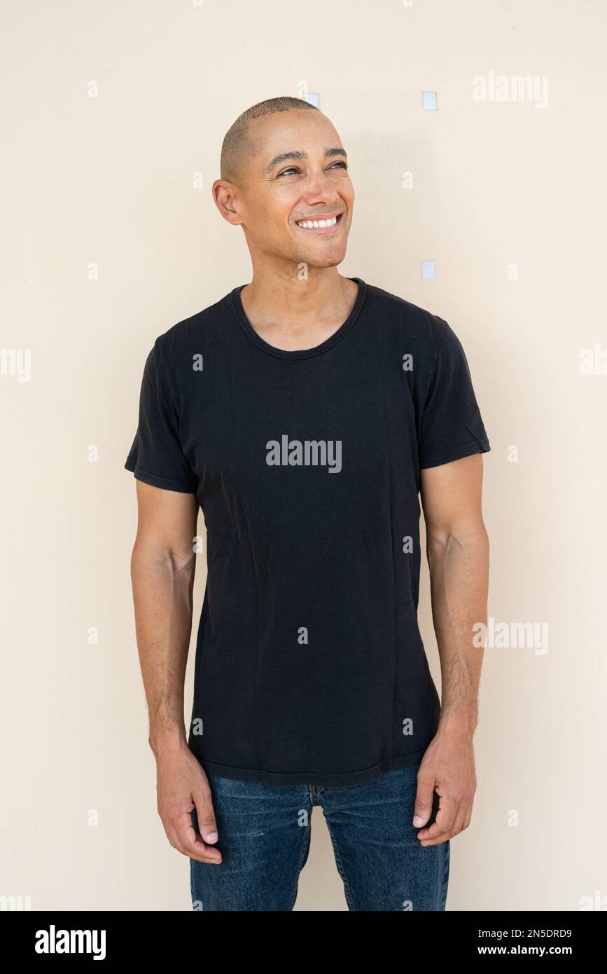 Porträt eines gutaussehenden, kahlen Mannes, der ein T-Shirt vor schlichtem Hintergrund trägt Stockfoto
