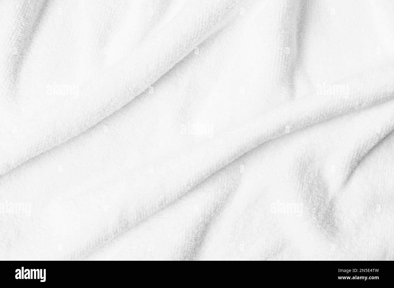 Strukturiertes weißes Handtuch aus natürlicher Baumwolle, Hintergrundfoto mit selektivem Fokus. Stockfoto