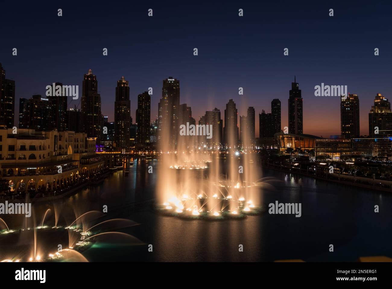 Dubai singende Brunnen bei Nacht Seeblick zwischen Wolkenkratzern. Moderne Architektur in der Dämmerung der Skyline der Stadt in der Innenstadt der Vereinigten Arabischen Emirate. Stockfoto