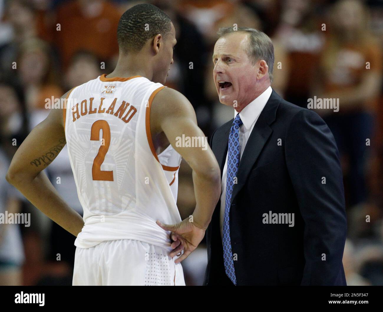 Texas coach Rick Barnes, right, talks to Demarcus Holland (2) during the second half of an NCAA college basketball game against West Virginia, Saturday, Feb. 15, 2014, in Austin, Texas. Texas won 88-71. (AP Photo/) Stockfoto