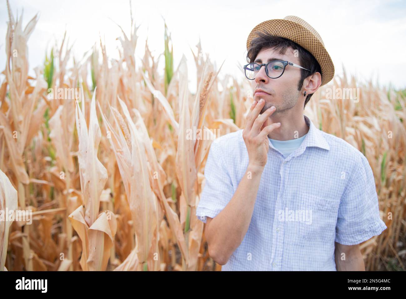 Ein Bauer ist aufmerksam und besorgt, weil die Dürre seine Felder ruiniert hat. Stockfoto