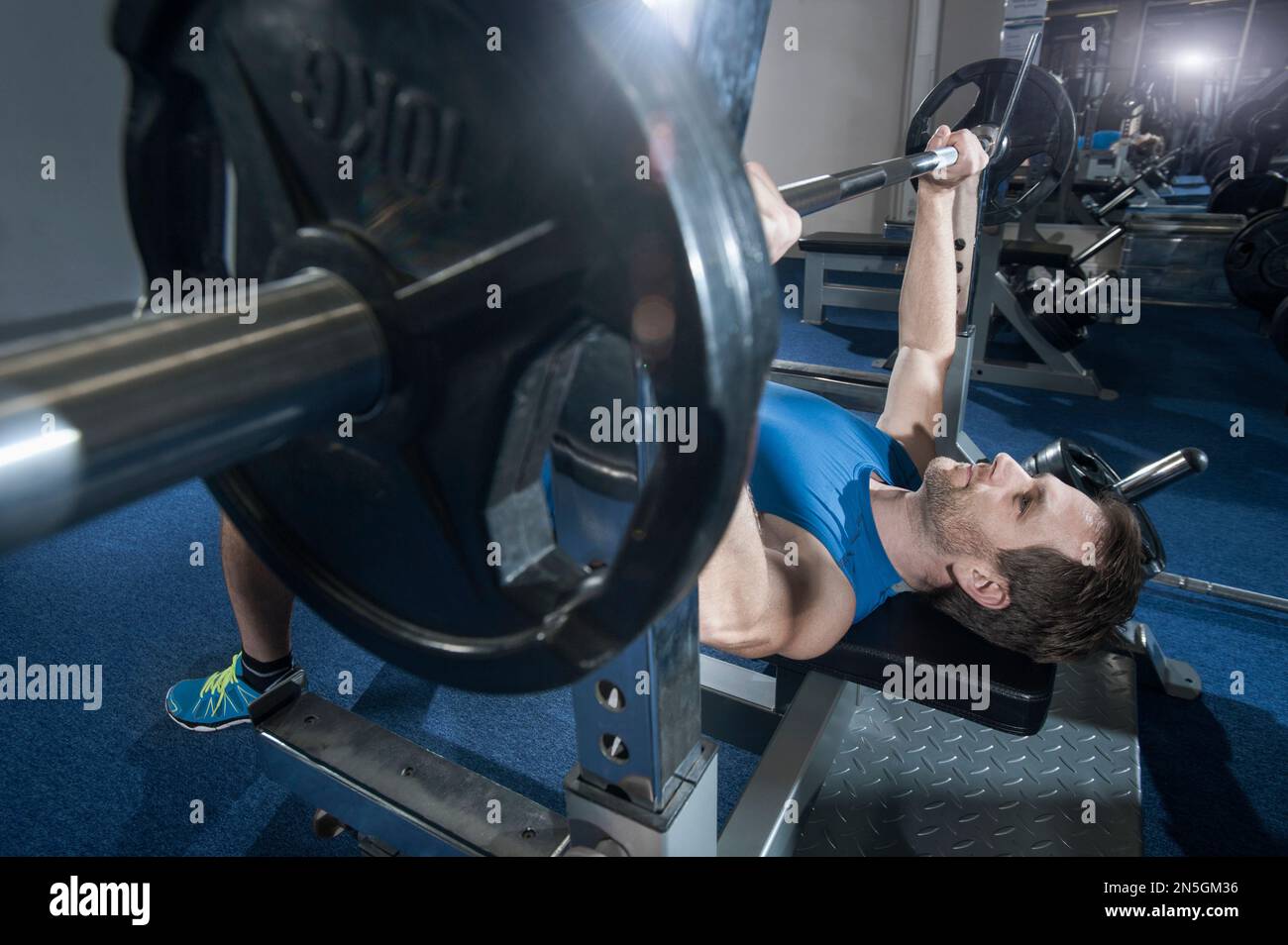 Ein erwachsener Mann, der im Fitnessstudio in Bayern Bankpresse macht Stockfoto