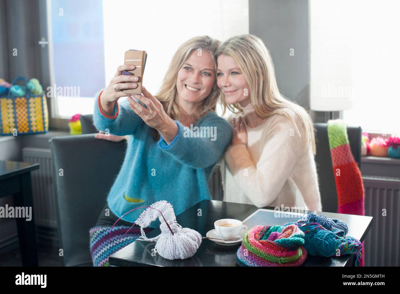 Zwei glückliche Freunde machen Selfie in einem Café in Bayern Stockfoto