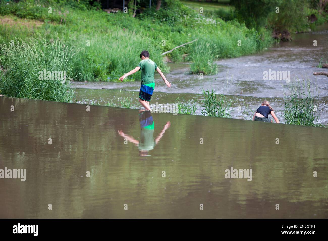 Kinder, die am Wehr des Flusses Diemel, Trendelburg, Kassel, Hessen, Deutschland, spielen Stockfoto