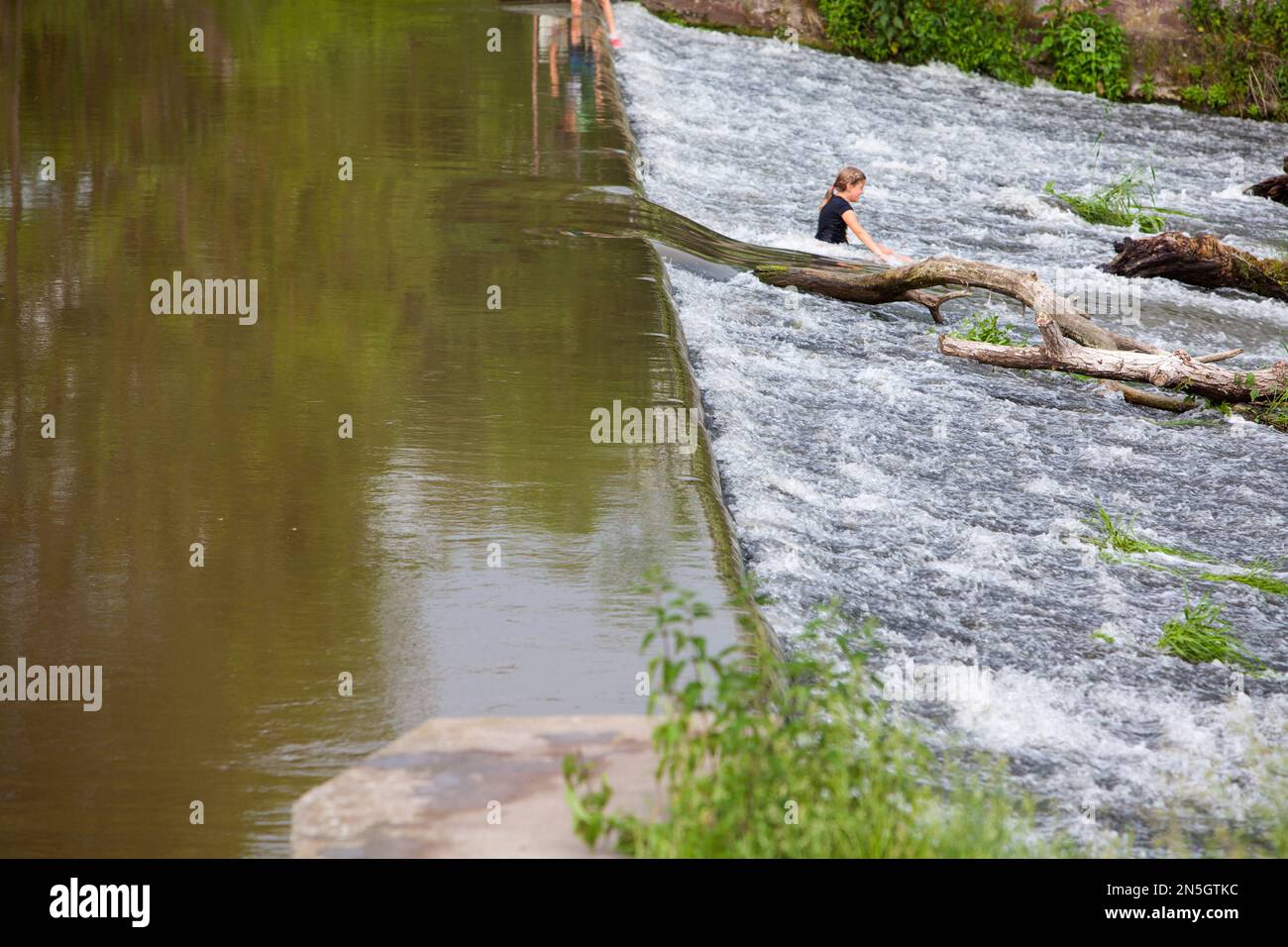 Kinder, die am Wehr des Flusses Diemel, Trendelburg, Kassel, Hessen, Deutschland, spielen Stockfoto