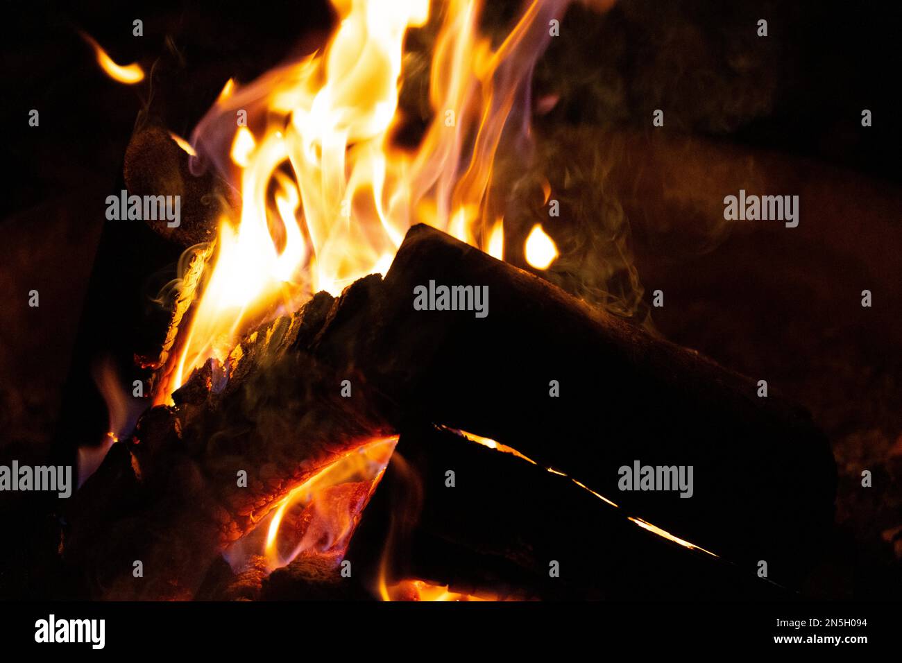 Ein glühendes Lagerfeuer, das Komfort und Wärme während einer kühlen Herbstnacht in einem Nationalpark bietet. Stockfoto