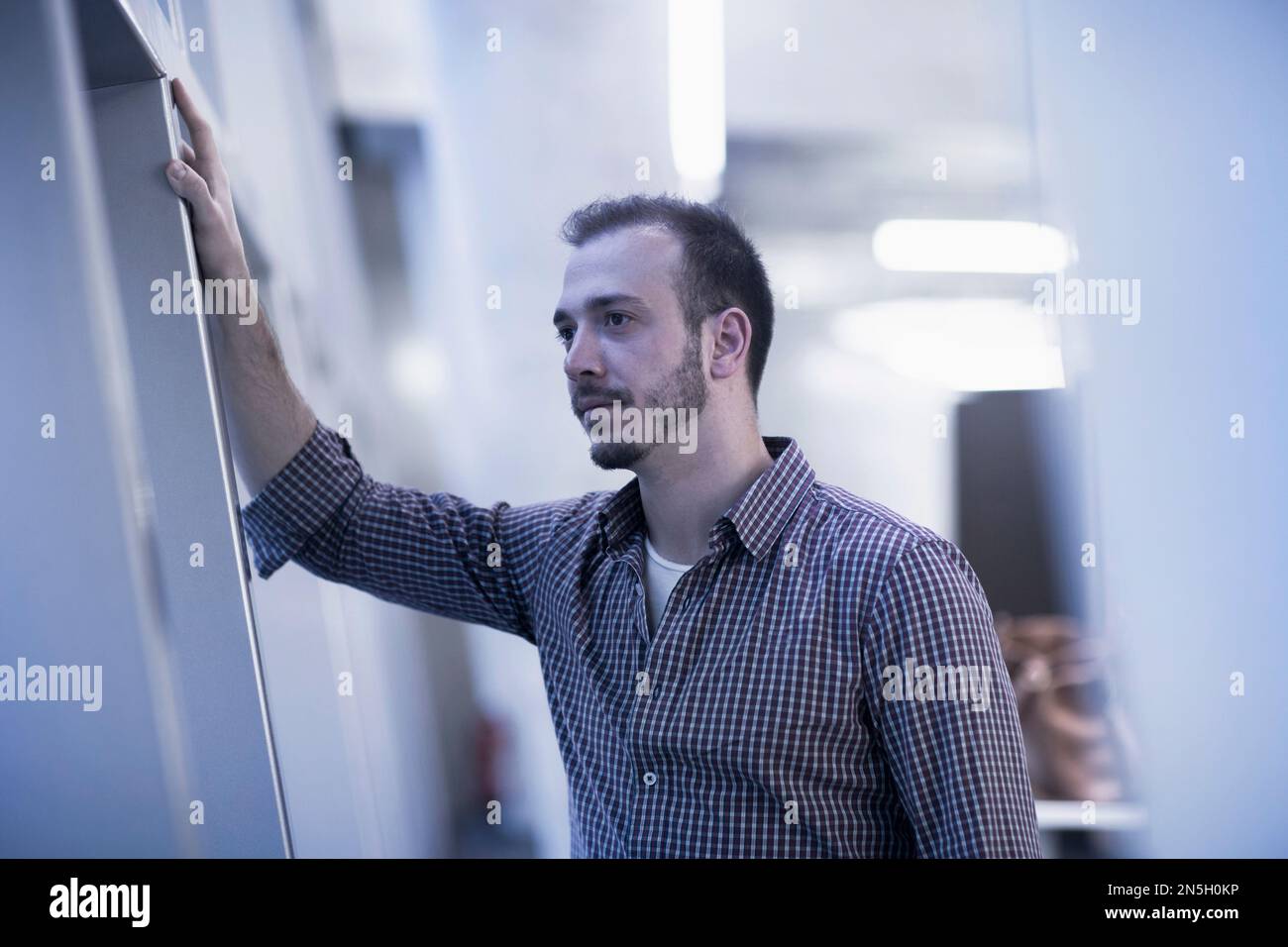 Aufmerksamer junger Geschäftsmann, der in einem Büro arbeitet, Freiburg im Breisgau, Baden-Württemberg, Deutschland Stockfoto