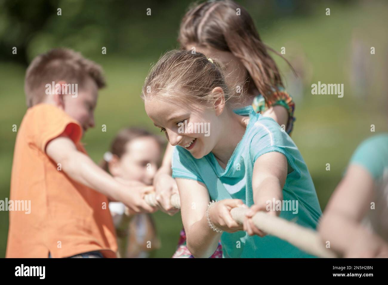 Eine Gruppe von Kindern, die im Park Tauziehen, München, Bayern, Deutschland Stockfoto