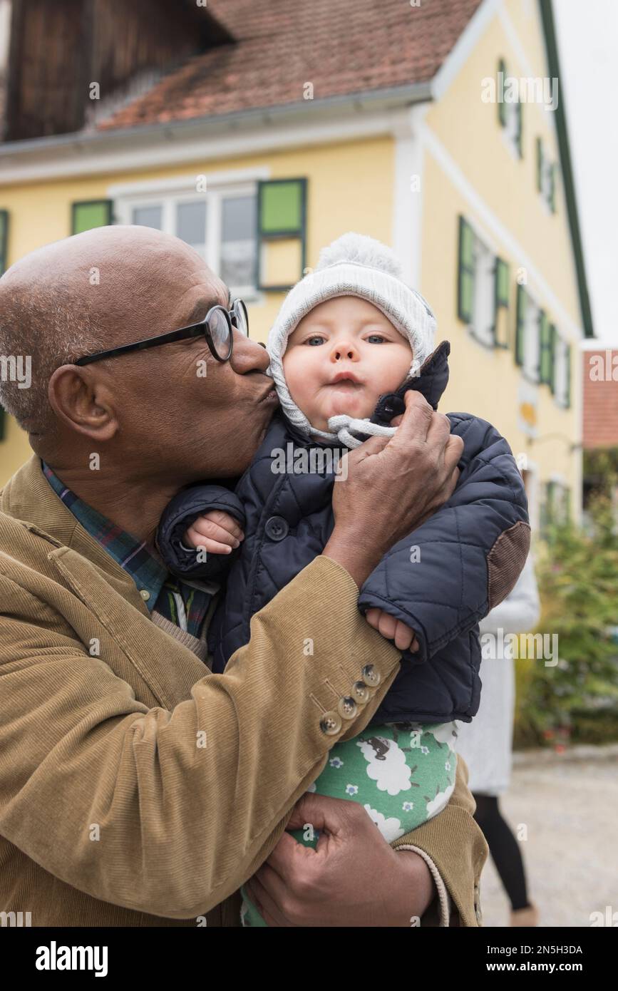 Schwarzer Senior, der seinen Enkel küsst, Bayern, Deutschland Stockfoto